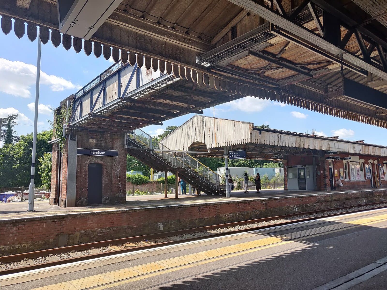 Platforms, footbridge and canopy at Fareham railway station, Hampshire, with the Fareham station sign