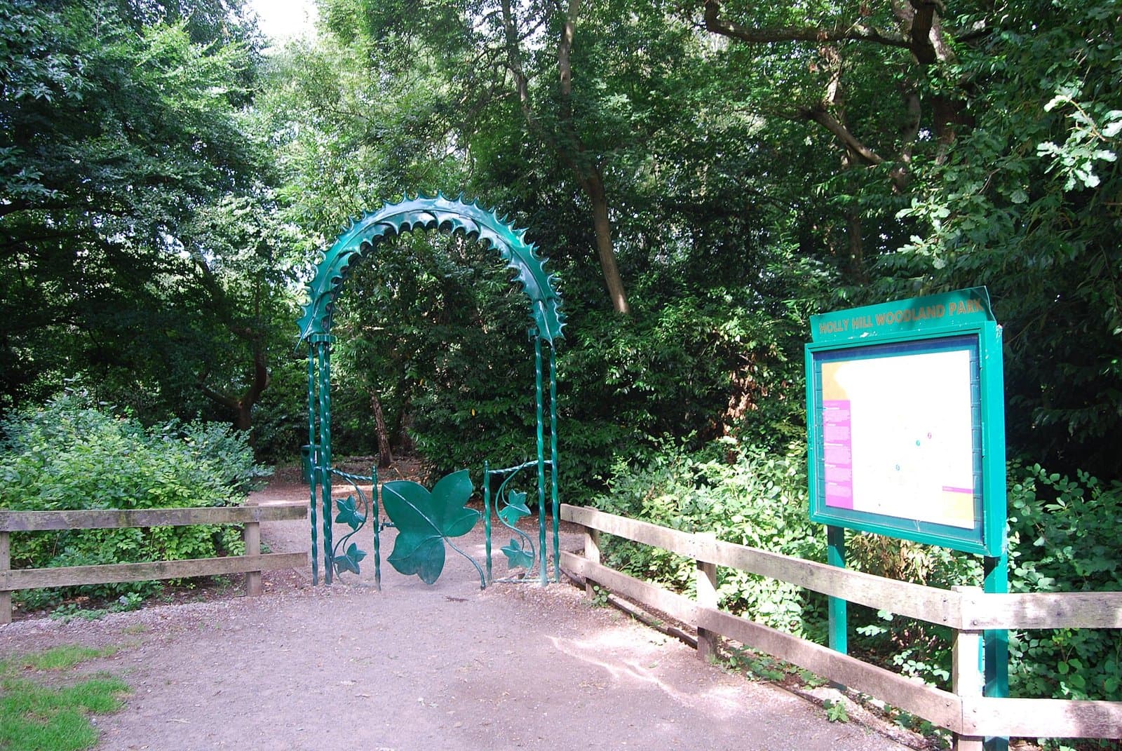 Green ivy-leaf entrance arch and information board at Holly Hill Woodland Park, Fareham