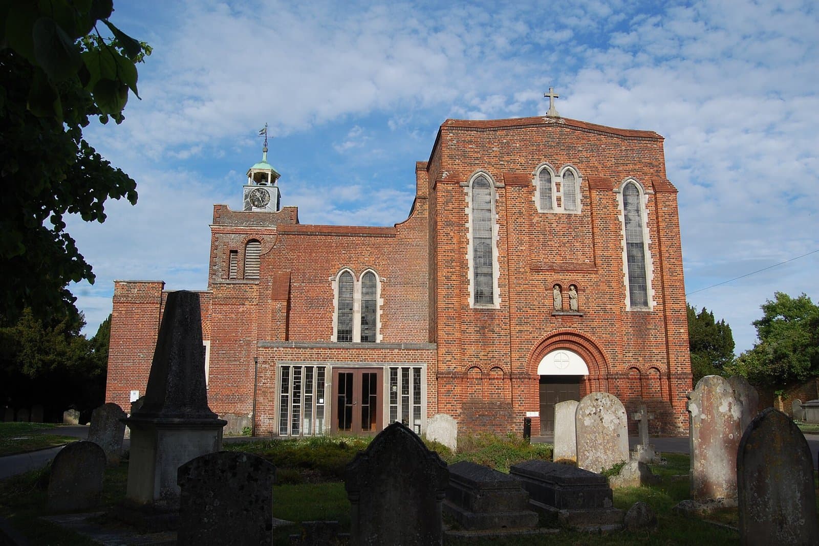 West front and clock turret of St Peter and St Paul's Church, Church Path, Fareham, seen across the churchyard