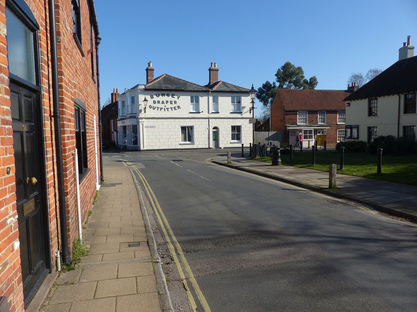 Corner of South Street and the village green in Titchfield, Fareham, with brick and rendered buildings in sunshine